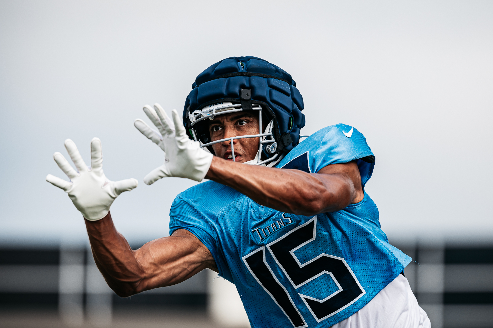Football players in practice wearing Guardian Cap helmet covers