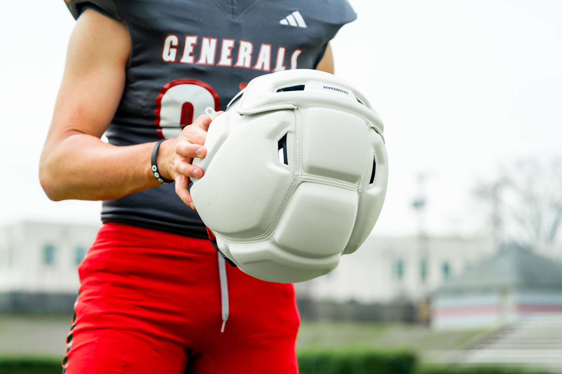 Close-up of a football player wearing a light-colored Guardian Cap during practice